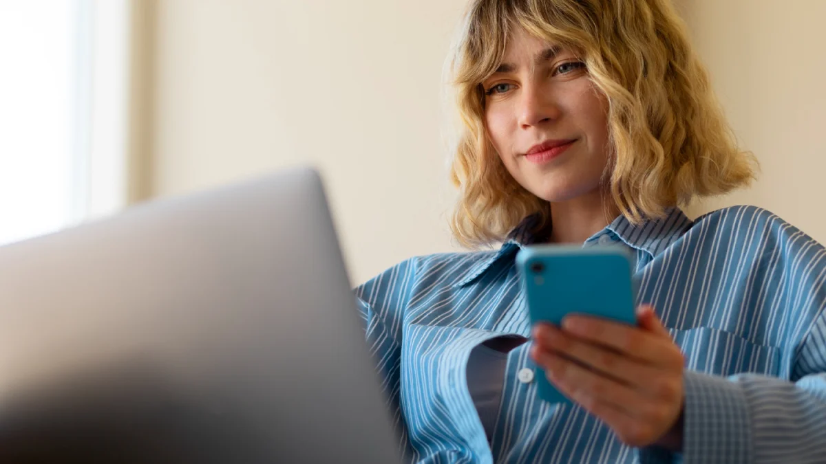 Woman looking at laptop and phone